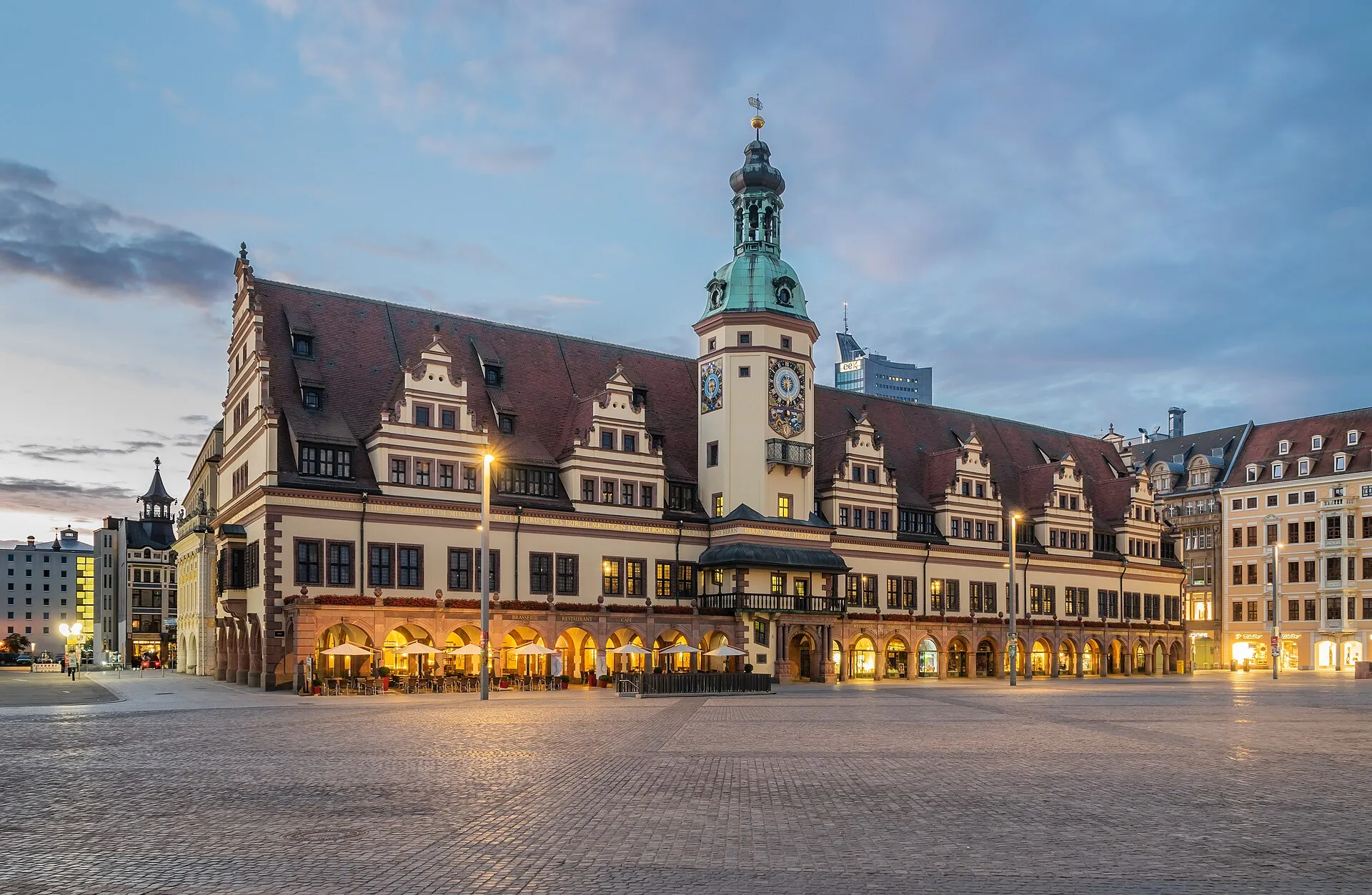 Altes Rathaus am Leipziger Markt in der Morgendämmerung, beleuchtete Arkaden über dem leeren Pflasterplatz